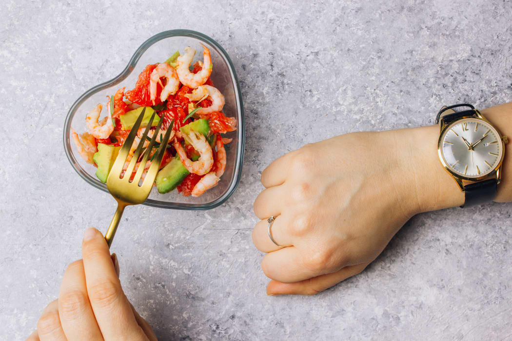 Intermittent fasting concept - countdown to eat salad with avocado, grapefruit and shrimps in bowl