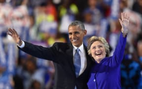 US President Barack Obama, left, waves with US presidential nominee Hillary Clinton during the third night of the Democratic National Convention in Philadelphia on 27 June (US time).