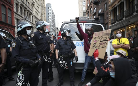 Protesters demand to kneel down from police officers with the call for unity during a protest in New York