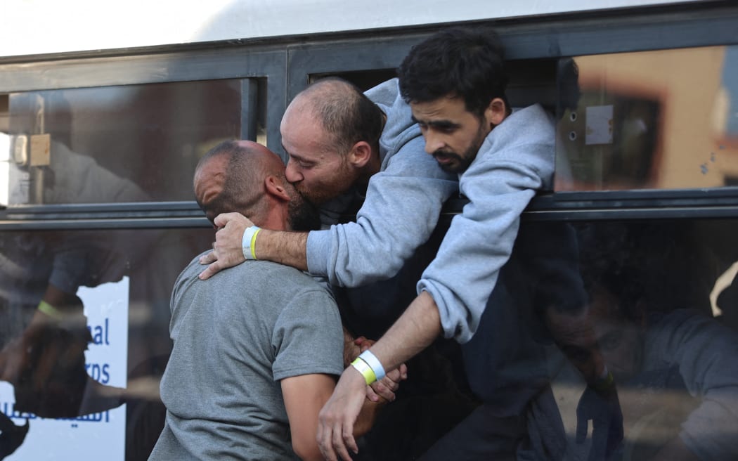 A Palestinian released from Israeli prisons under a Gaza ceasefire and hostage exchange deal with Palestinian factions, greets a relative as he arrives on a bus outside the Nasser hospital in Khan Yunis in the southern Gaza Strip on October 13, 2025. (Photo by Omar AL-QATTAA / AFP)