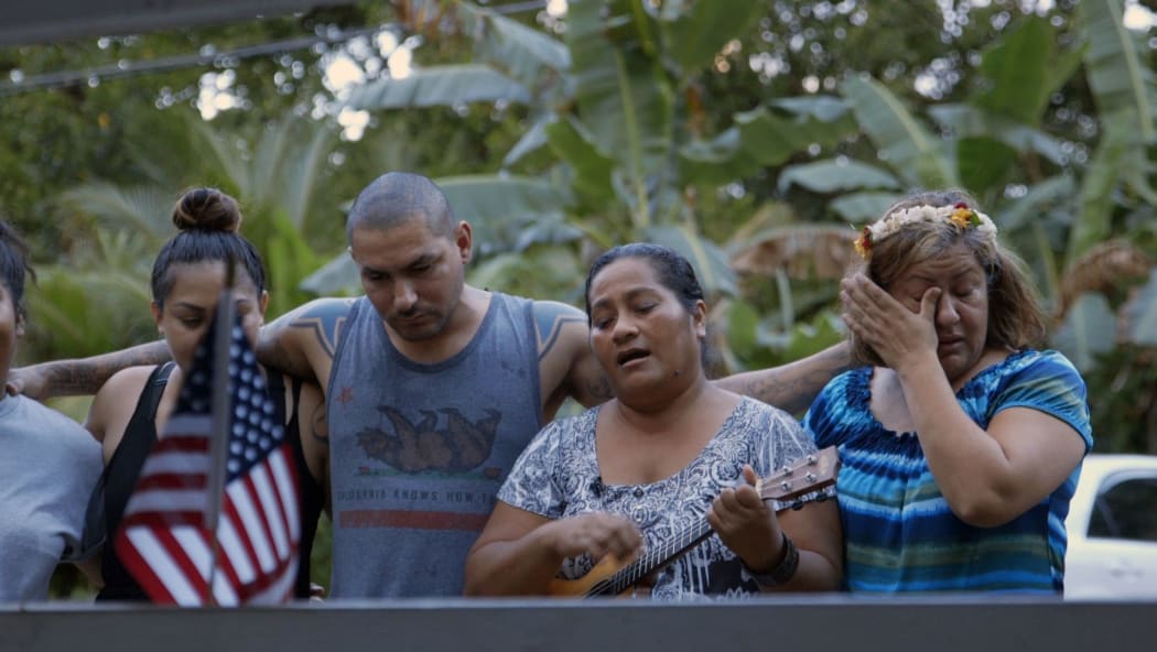 Maryann Nena sings by the grave of her son, SGT Sapuro B. Nena, who was killed in action in Afghanistan in 2012.  Mario Robles, to her left, was Sapuro's best friend in the US Army, and he and his family flew to the FSM in 2015 to pay their last respects.