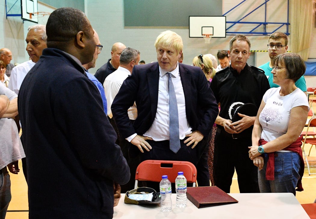 Britain's Prime Minister Boris Johnson meets with rescue crews and local residents at Chapel-en-Le-frith High School,