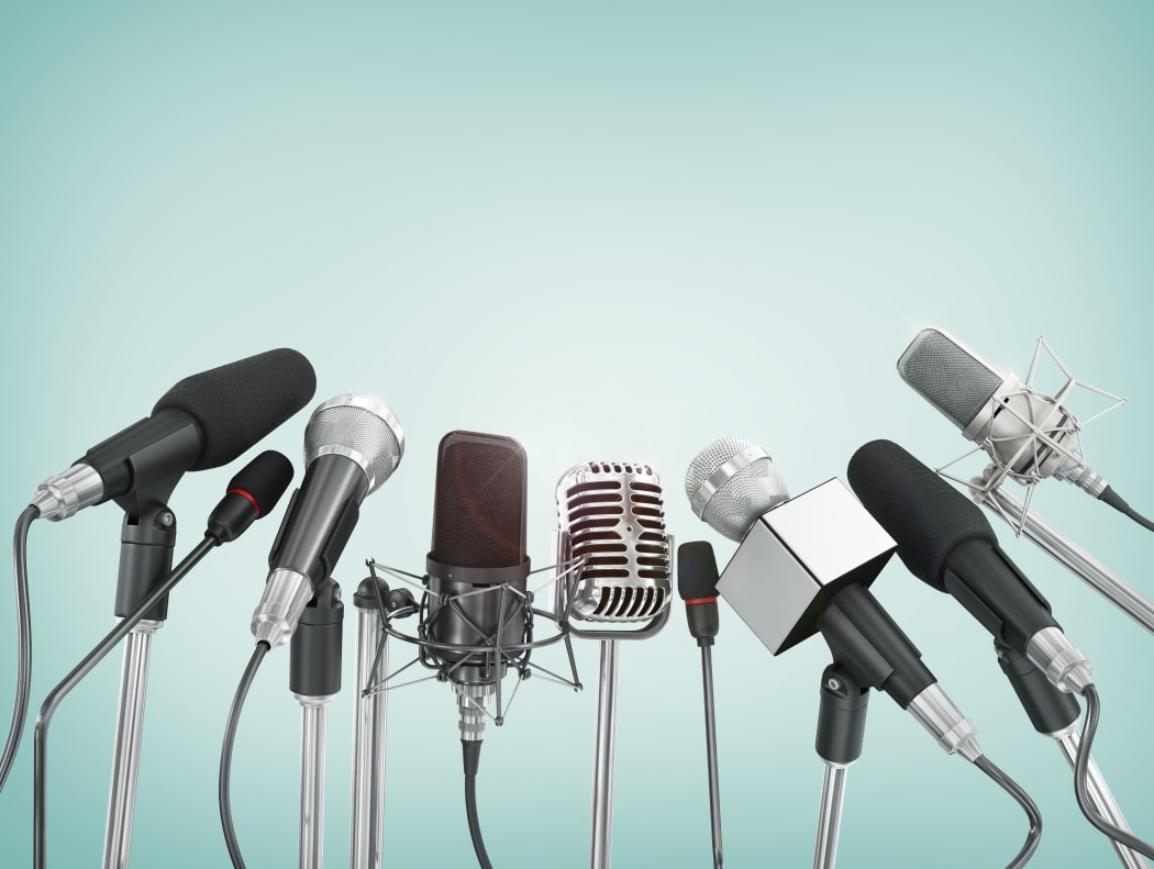 Various microphones aligned at press conference.