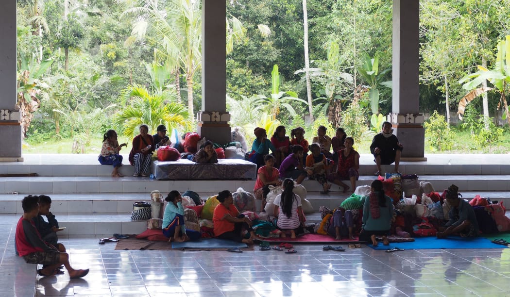 People gather at an evacuation area with their belongings in Klungkung regency in Bali.