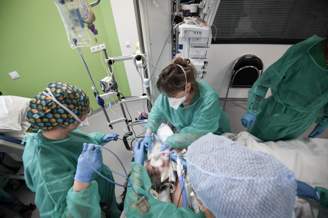 Nurses tend to a Covid-19 patient at the intensive care unit of the Delafontaine AP-HP hospital in Saint-Denis, outside Paris, on December 29, 2021.