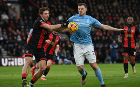 Bournemouth's Spanish defender Dean Huijsen (L) vies with Nottingham Forest's New Zealand striker 11 Chris Wood, 2025.