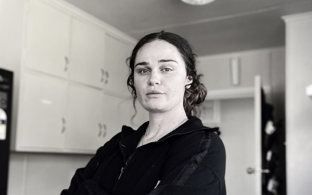 Erin Speedy of Mission Homefront stands crossing their arms in a house.