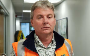 A man wearing an orange vest.