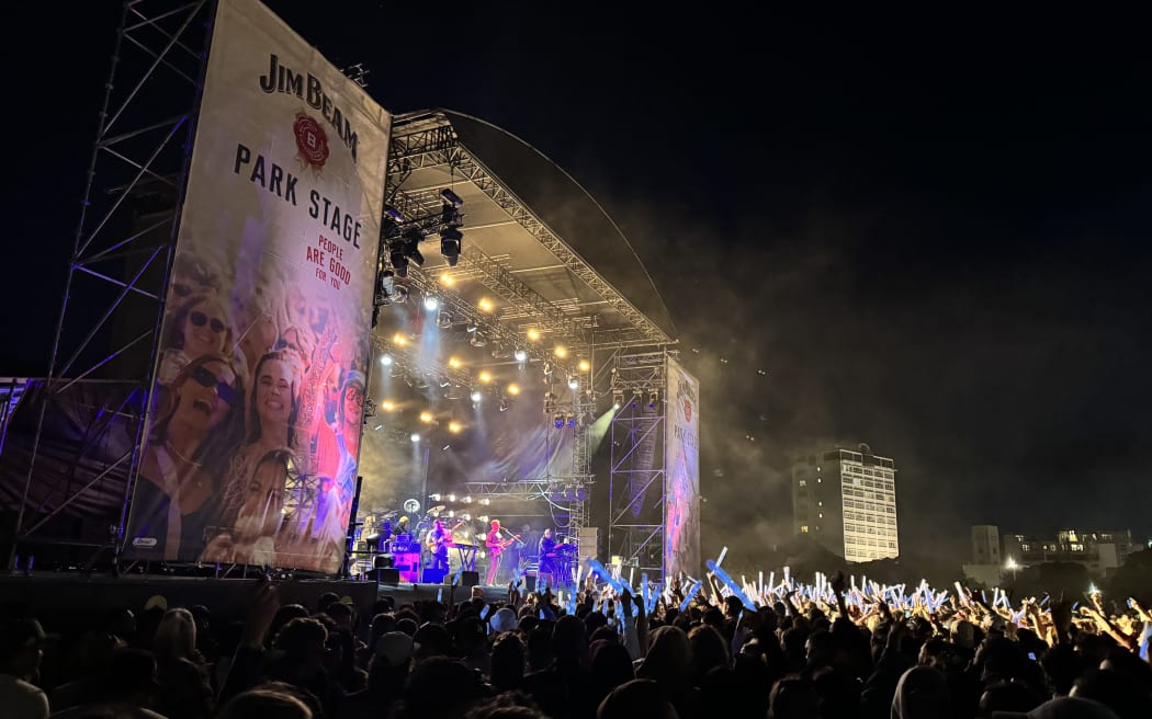 L.A.B performing on stage at night under pink and purple lighting.