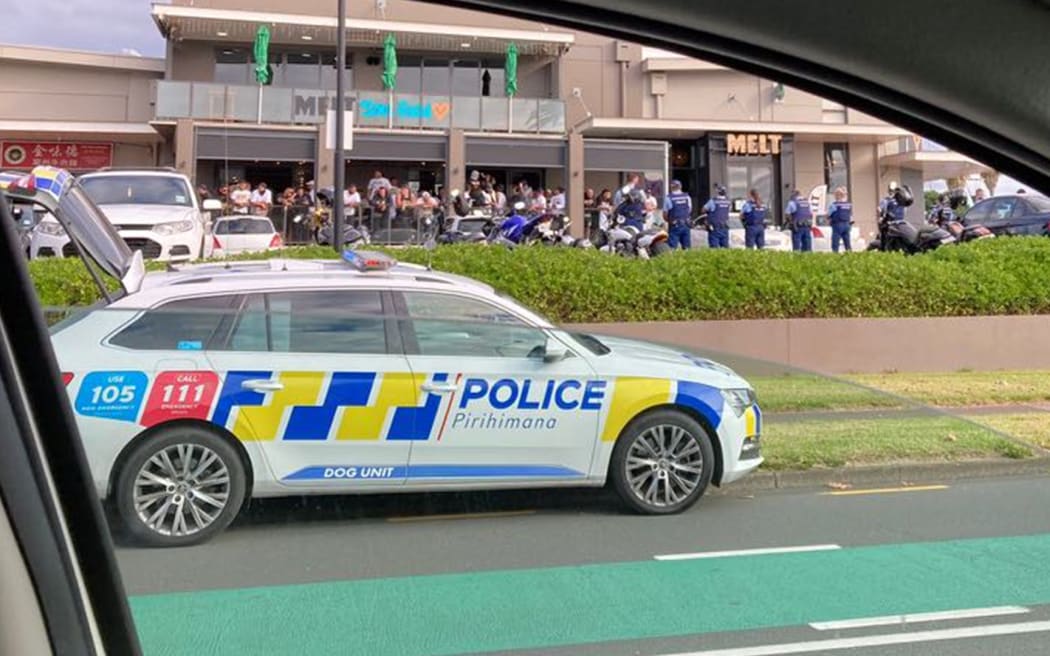 Police are outside a restaurant where a large gang presence has congregated.