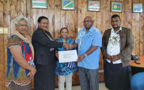 Vanuatu’s Special Envoy for West Papua, Lora Lini, hands over the United Liberation Movement for West Papua's application for full membership in the Melanesian Spearhead group to the MSG Deputy Director General Peter Eafeare. ULMWP executive member Paula Makabory (middle) observes.