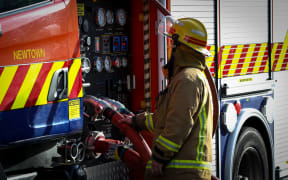 Fire fighter checking the pressures of the appliance at 242 Adelaide Road, Newtown.