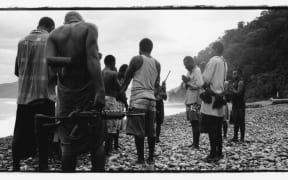 Harold Keke (centre, praying) and his GLF guerillas pray on a beach before patrolling, along the Weathercoast, Guadalcanal, Solomon Islands,
2003