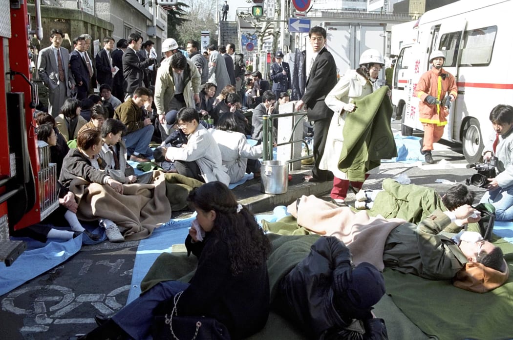 The passengers of subway lie down on a street at Hacchobori Station in Tokyo on 20 March, 1995 after a sarin attack.