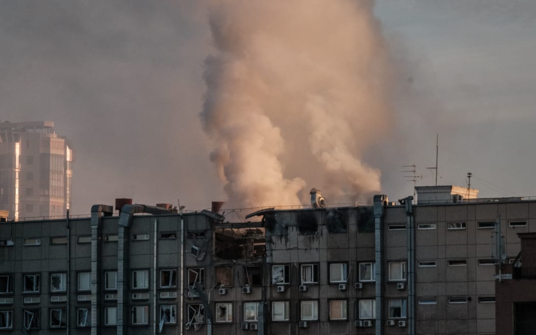 Smoke rises from a partially destroyed building in Kyiv on October 17, 2022, amid the Russian invasion of Ukraine. (Photo by Yasuyoshi CHIBA / AFP)