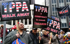 The crowd preparing to march on parliament in Wellington with anti-corporation slogans and signs.