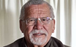 Harry Walker looks at the camera in spectacles and a brown sweater.