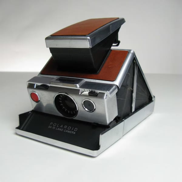 A steel and wood-finished old-fashioned looking camera.