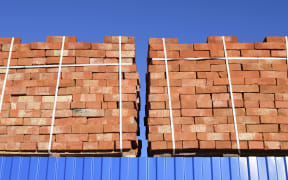 Red bricks stacked into cubes. Warehouse bricks. Storage brickworks products.