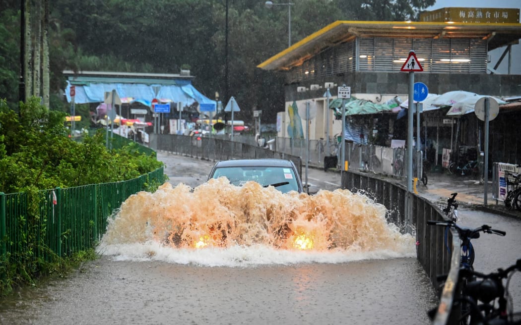 A motorist drives through floodwaters on Lantau Island in Hong Kong on September 8, 2023. Record rainfall in Hong Kong caused widespread flooding in the early hours on September 8, disrupting road and rail traffic just days after the city dodged major damage from a super typhoon. (Photo by Peter PARKS / AFP)