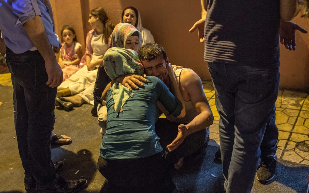 People gather near the explosion site in Gaziantep in the wake of the attack on a wedding party in southeastern Turkey.