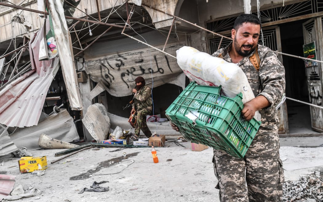 Free Syrian Army fighters loot shops after seizing control of the centre of Syrian-Kurdish city Afrin.