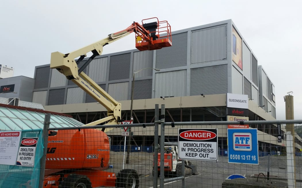 Demolition teams stand ready to start the disassembly of the Queensgate Mall.