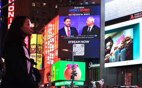 A screen displays the CBS vice presidential debate between US Senator and Republican vice presidential candidate J.D. Vance and Minnesota Governor and Democratic vice presidential candidate Tim Walz in Times Square in New York on October 1, 2024. (Photo by Kena Betancur / AFP)