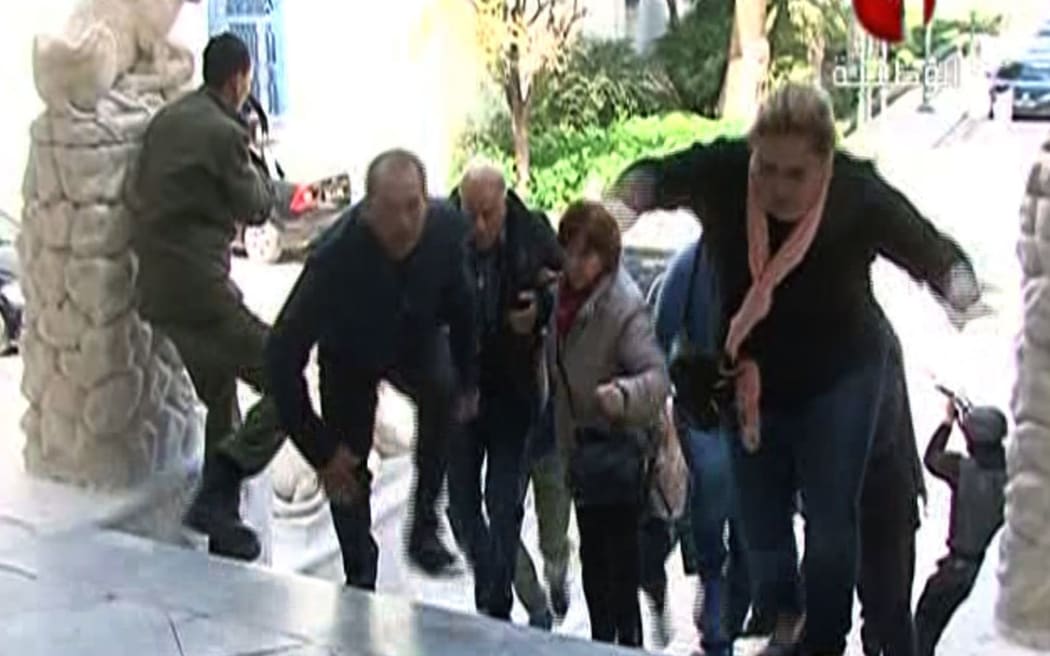 People escaping from Tunis' famed Bardo Museum during an attack by two men armed with assault rifles.