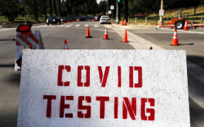 People in cars (TOP L) are lined up to be tested for COVID-19 as they make their way to a parking lot at Dodger Stadium amid the coronavirus pandemic on June 26, 2020 in Los Angeles, California.