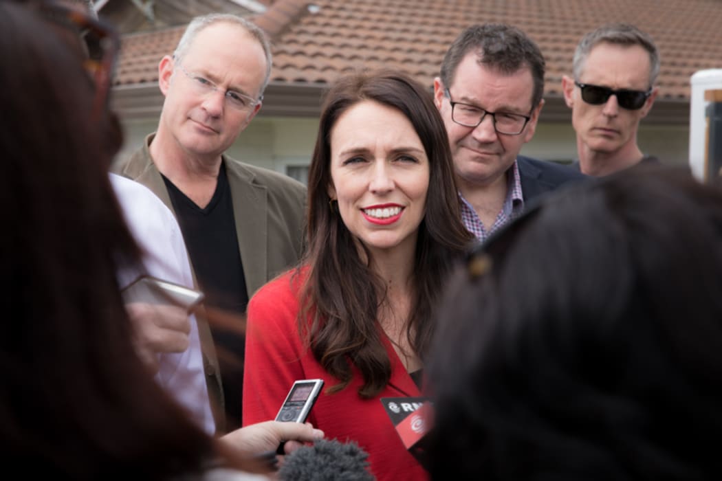 Jacinda Ardern (centre) speaking to media outside her home in Pt. Chevalier, Auckland. Phil Twyford (left) and Grant Robertson (right) stand with her.