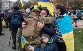 Local residents hug a Ukrainian soldier as they celebrate the liberation of Kherson, on November 14.