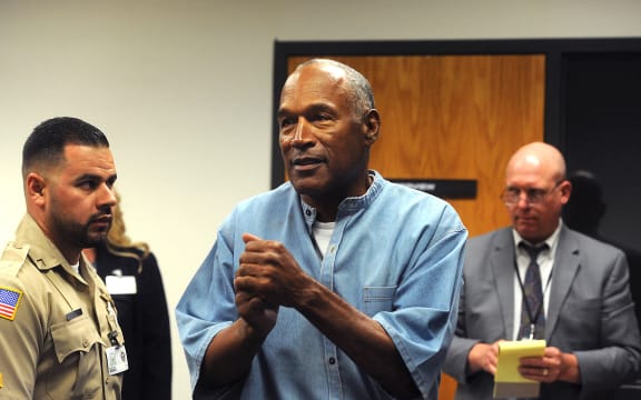 O.J. Simpson (C) reacts after learning he was granted parole during his parole hearing at the Lovelock Correctional Center in Lovelock, Nevada on July 20, 2017. Disgraced former American football star O.J. Simpson was granted his release from prison on Thursday after serving nearly nine years behind bars for armed robbery.A four-member parole board in the western US state of Nevada voted unanimously to free the 70-year-old Simpson after a public hearing broadcast live by US television networks. (Photo by Jason Bean / POOL / AFP)