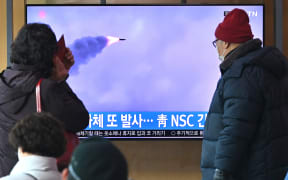 People watch a news broadcast with file footage of a North Korean missile test, at a railway station in Seoul on 27 February 2022.
