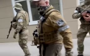 This video grab taken from handout footage posted on June 24, 2023 on the Telegram channel @razgruzka_vagnera shows Yevgeny Prigozhin (C) walking in the city of Rostov-on-Don.