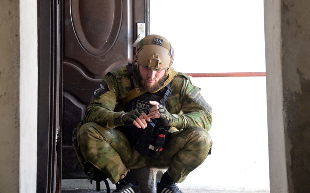 A service member of Akhmat Kadyrov specialist police regiment is seen in a church of St George in the settlement of Komishuvakha, Luhansk. Russian forces are now advancing strongly in the region.