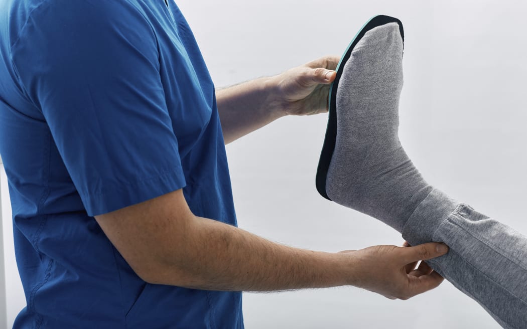Orthopedist fitting orthopedic insole. (Photo by PEAKSTOCK / SCIENCE PHOTO LIBRAR / LDA / Science Photo Library via AFP)