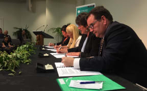 Government ministers Grant Robertson and Nanaia Mahuta, Te Puni Kōkiri chief executive Michelle Hippolite, and Parihaka rep Tina Mason sign the deal.