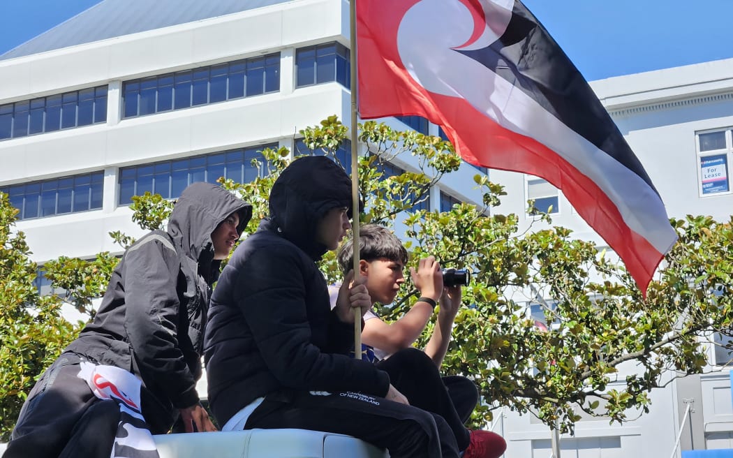 Tamariki get the best of view of the hīkoi as it passes through Palmerston North.