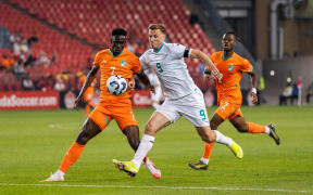 Odilan Kossounou #7 of Cote d'Ivoire battles for the ball against Chris Wood #9 of New Zealand.
