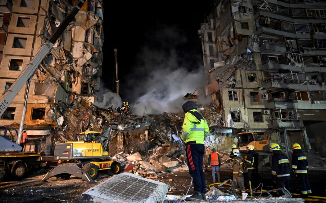 EDITORS NOTE: Graphic content / Rescuers work on a residential building destroyed after a missile strike, in Dnipro on January 15, 2023, amid the Russian invasion of Ukraine. - The death toll rose to at least 20 on January 15 after a strike on a residential building in Dnipro on January 14, a city in centre-east Ukraine, the Ukrainian regional governor said. (Photo by SERGEI CHUZAVKOV / AFP)