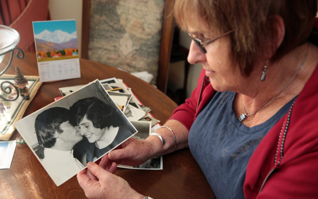Lynda Mathews holding her photo with John Lennon, her second cousin.
