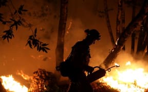 CalFire firefighter Brandon Tolp uses a drip torch during a firing operation near Calistoga, California.