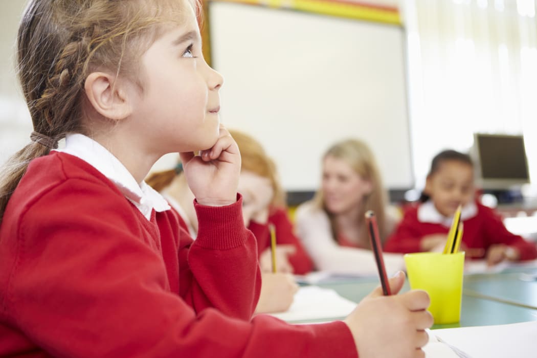 Female Elementary Pupil Working At Desk