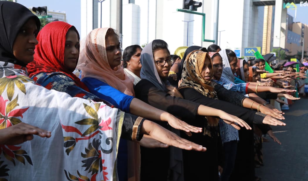 Indian women hold out their hands as they stand in a line to take part in a "women's wall" protest in Kochi in southern Kerala state.