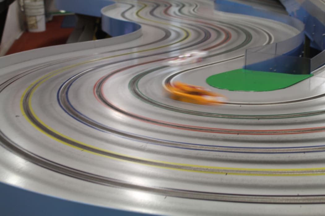 An image of a slot car racing around the track. A lap takes less than five seconds to complete.