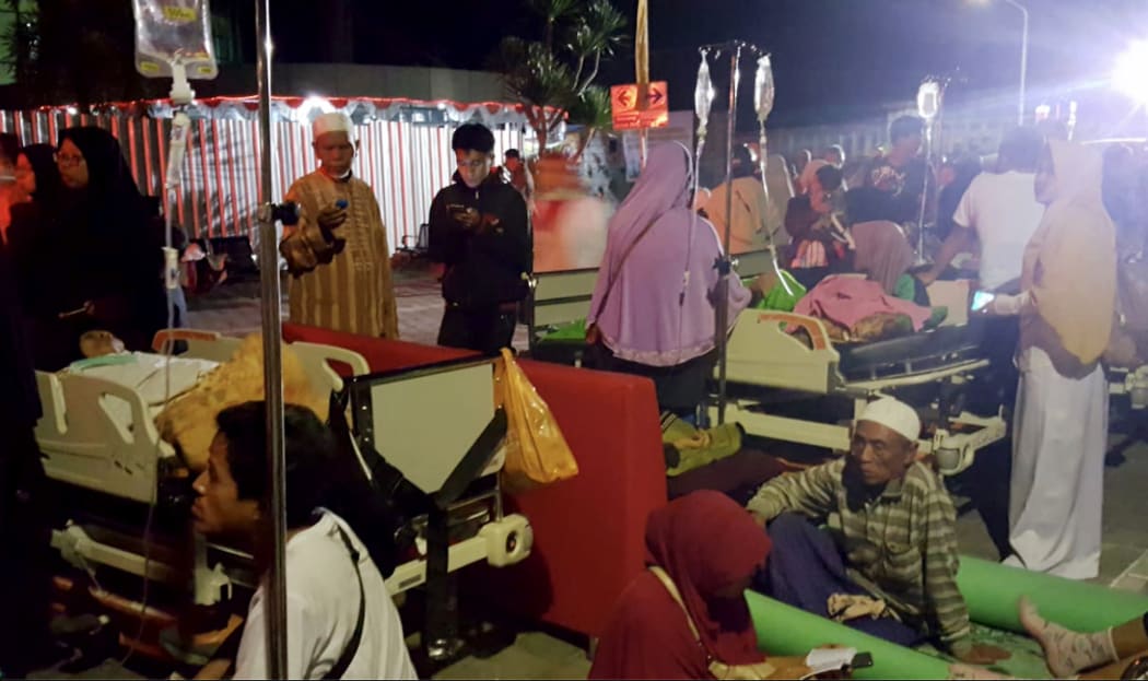 Hospital patients and relatives wait outside after being evacuated after an earthquake rocked Indonesia's Lombok island.