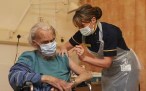 Trevor Cowlett, 88, receives the Oxford University/AstraZeneca Covid-19 vaccine from a nurse at the Churchill Hospital in Oxford, southwest England on January 4, 2021.