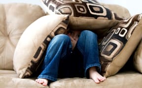 Boy hiding in cushions