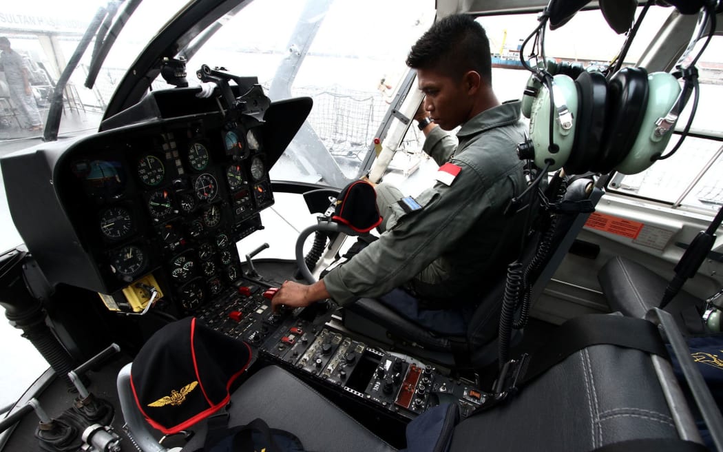 Indonesian Navy helicopter pilots assist in the search for missing AirAsia flight QZ8501.